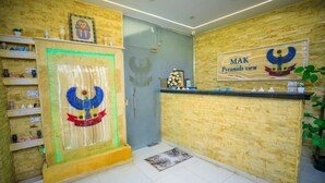 A reception area with a wooden wall, a glass door, and a sign reading "MAK Pyramids view". - Mak Pyramids View (Giza)