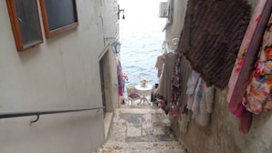 Una estrecha escalera de piedra que lleva a un balcón con vistas al mar.