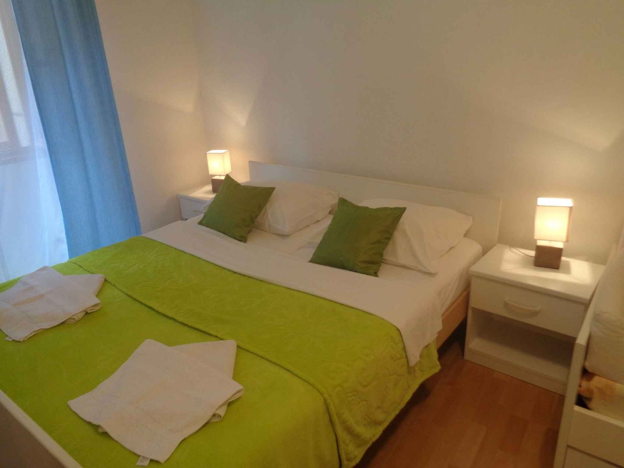 A hotel room with a bed, two bedside tables, and a nightstand.