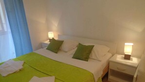 Una habitación de hotel con una cama, dos mesitas de noche y un aparador.