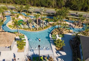 Vue aérienne d’un complexe hôtelier doté de plusieurs piscines, de palmiers et d’espaces de détente.