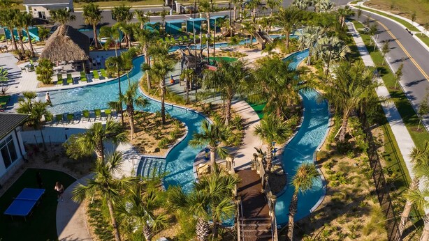 An aerial view of a resort with a large pool area, palm trees, and a thatched-roof structure. - Storey Lake Resort, Private Pool, Near Famous Attractions!! (Kissimmee)