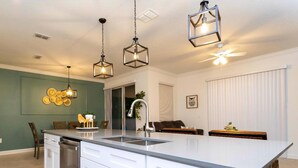 A modern kitchen with a large island, white cabinetry, and pendant lighting. - Storey Lake Resort, Private Pool, Near Famous Attractions!! (Kissimmee)