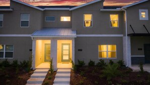 A modern two-story building with a flat roof, a central entrance with a glass door, and multiple windows. - Storey Lake Resort, Private Pool, Near Famous Attractions!! (Kissimmee)