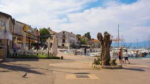 Ein Yachthafen mit Booten, einem zentralen Baum und Außenbereich-Sitzgelegenheiten.