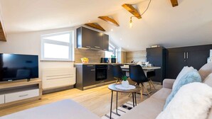 Een modern appartement met keuken, eethoek en woonkamer.