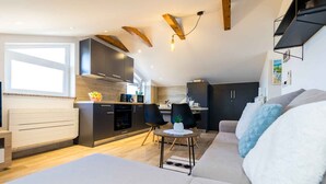 Een moderne woonkamer met een bank, een salontafel en een eethoek met stoelen.