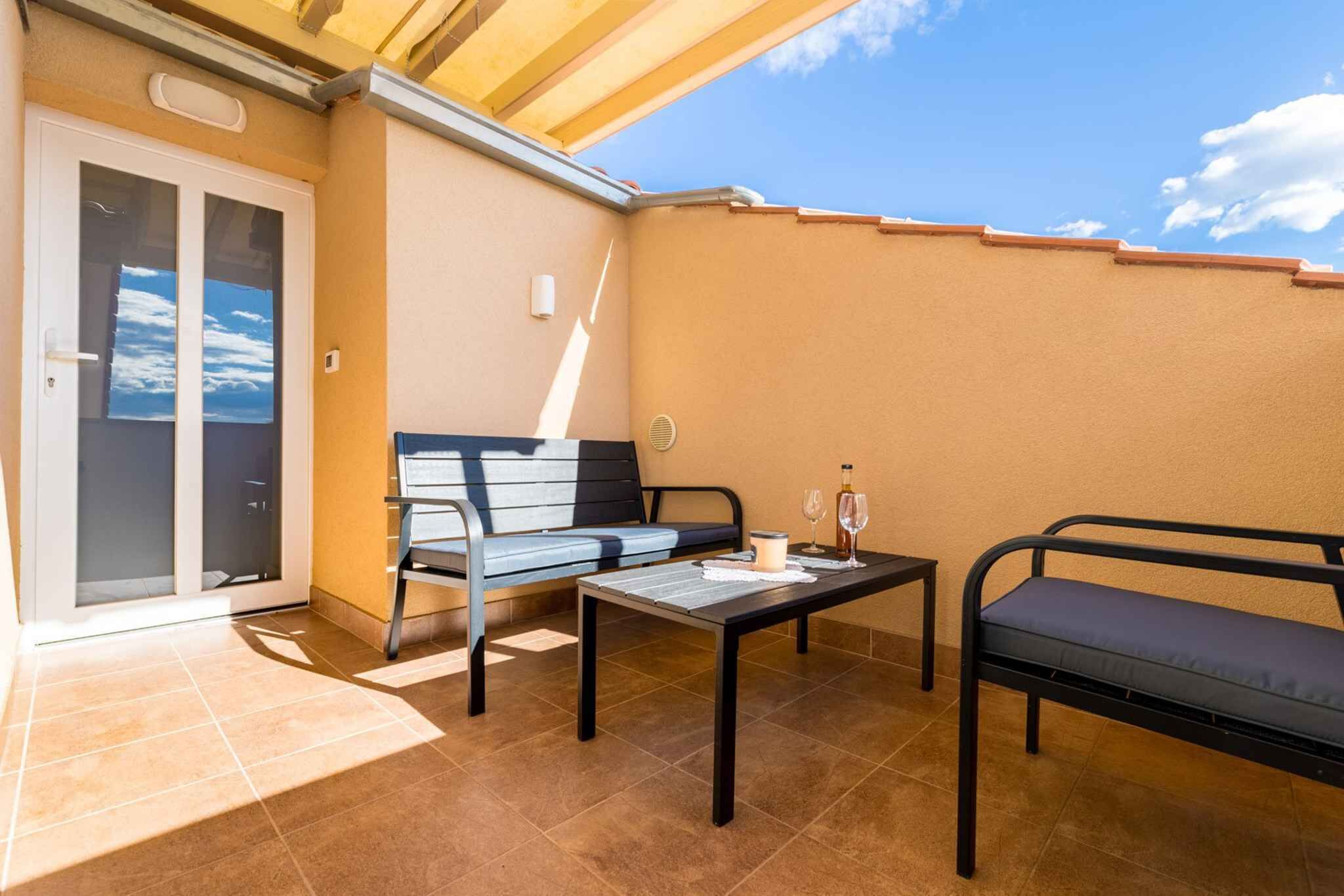 A balcony with a sofa, a table, and a bench.