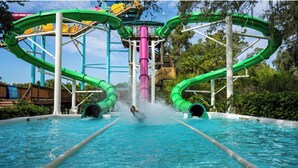 Un parque acuático con múltiples toboganes y una fuente central.