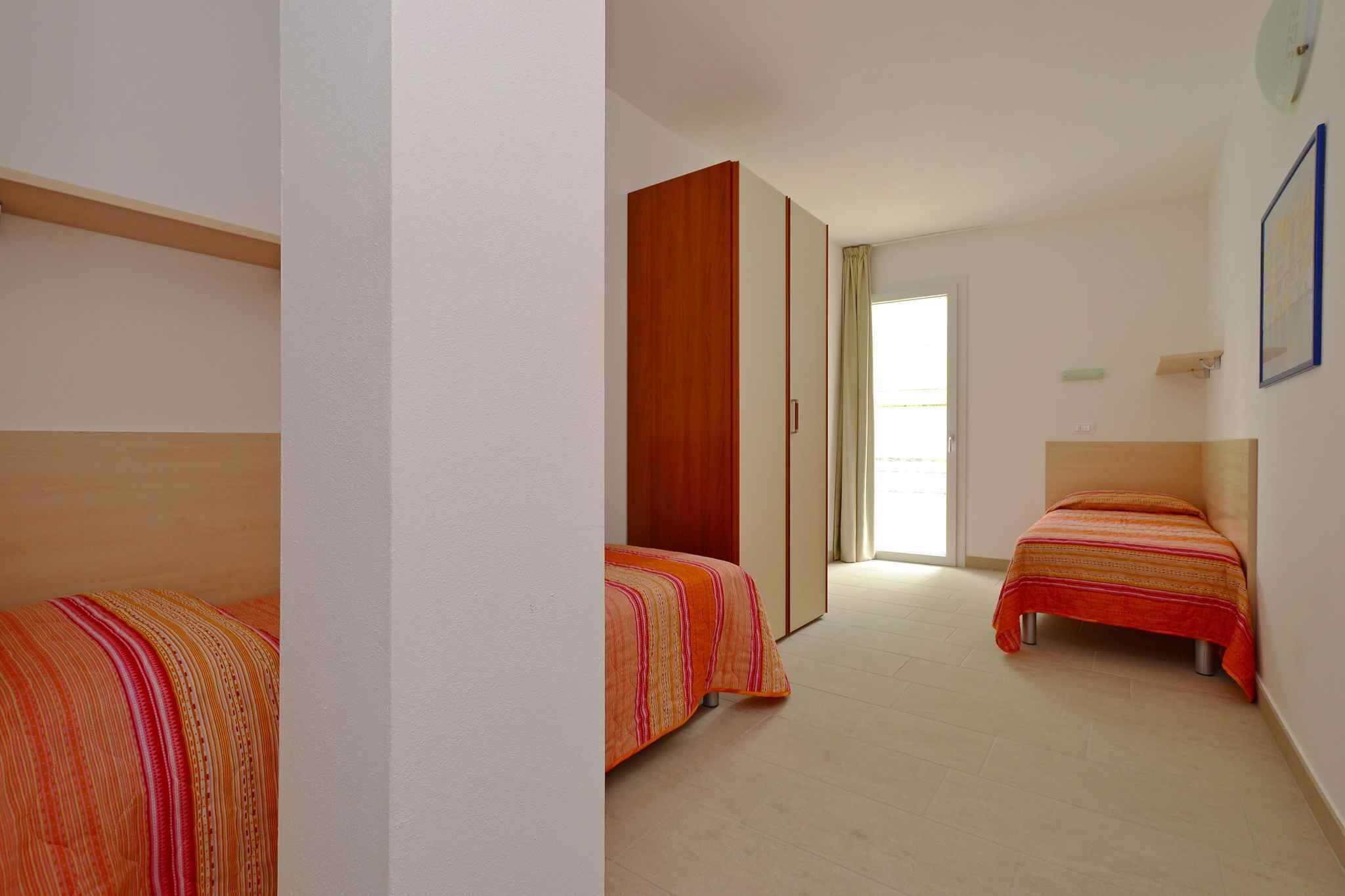 A bedroom with two single beds, a wardrobe, and a window.