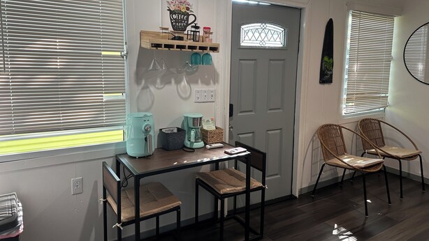 A compact kitchen with a coffee maker, a small table, and two chairs. - Tiny Wooden Home in Vega Baja with pool and close to the beach (Vega Baja)