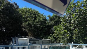 A clear blue pool with a brick border, surrounded by a white fence and trees. - Tiny Wooden Home in Vega Baja with pool and close to the beach (Vega Baja)