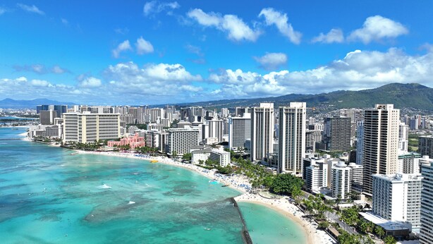 A coastal cityscape with high-rise buildings, a beach, and clear turquoise waters. - Comfortable King Bed Waikiki Studio 2 mins walk to Beach with WiFi & AC (Honolulu)