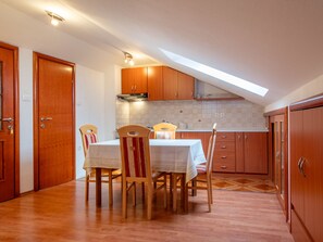 Enjoy meals in this kitchen with a dining table, oven, and tiled backsplash.