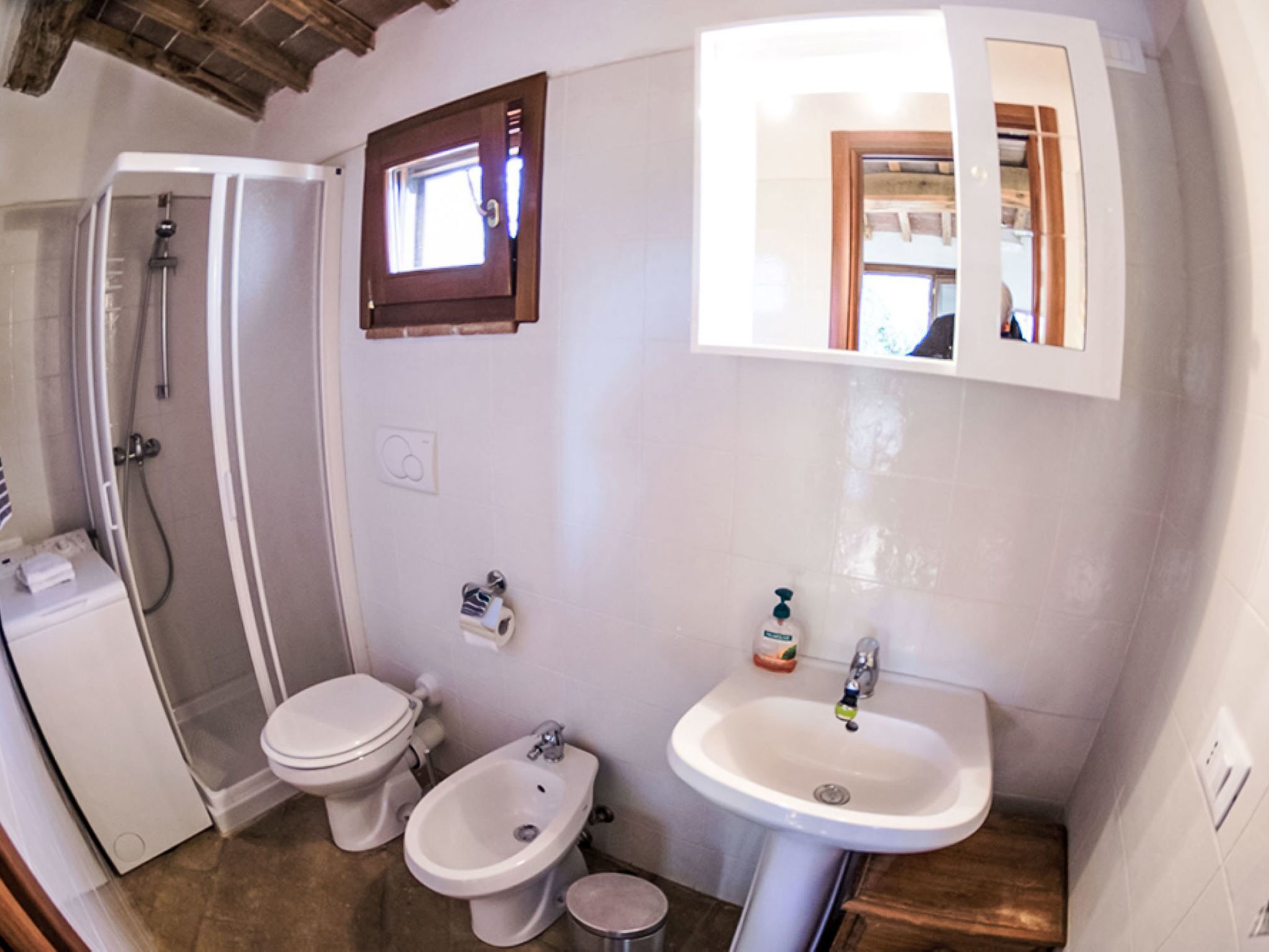 Een badkamer met douche, toilet, wastafel en bidet.