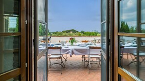An open patio with a table set for dining, overlooking a scenic landscape. - Tramonto by Interhome (Guardistallo)