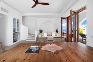 Un interior moderno con una mesa de comedor de madera, un sofá y una escalera.