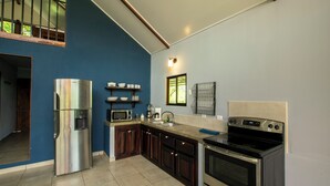 A modern kitchen with a stainless steel refrigerator, a microwave, a coffee maker, and an oven. - Casa Sloth, enchanting private house near La Fortuna. (Provincia de Alajuela)