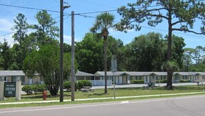 A row of motel buildings with a fire hydrant and trees in front. - High Springs Country Inn (High Springs)