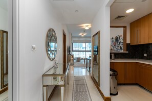 A modern kitchen with wooden cabinets, a stainless steel sink, and a large window offering a city view. - 1BR Apt in Prime Location w/ Marina View Balcony (Dubai)