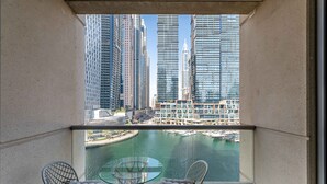 A balcony with two chairs and a glass table, overlooking a marina and high-rise buildings. - 1BR Apt in Prime Location w/ Marina View Balcony (Dubai)