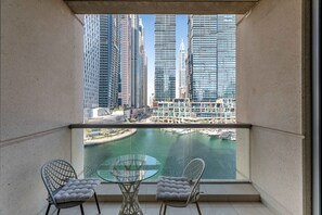 A balcony with two chairs and a glass table, overlooking a marina and high-rise buildings. - 1BR Apt in Prime Location w/ Marina View Balcony (Dubai)