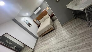 A hotel room with a bed, a bathroom with a sink, and a mirror. - Hotel Colonial Inn  (Tijuana)