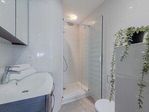 A modern bathroom with a glass-enclosed shower, a white sink, and a toilet. - Palmyra by Interhome (Le Barcarès)