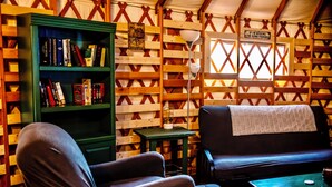 A cozy interior with a green bookshelf, a black sofa, and a small table. - Sportsman's Bungalow on Toledo Bend (Many)