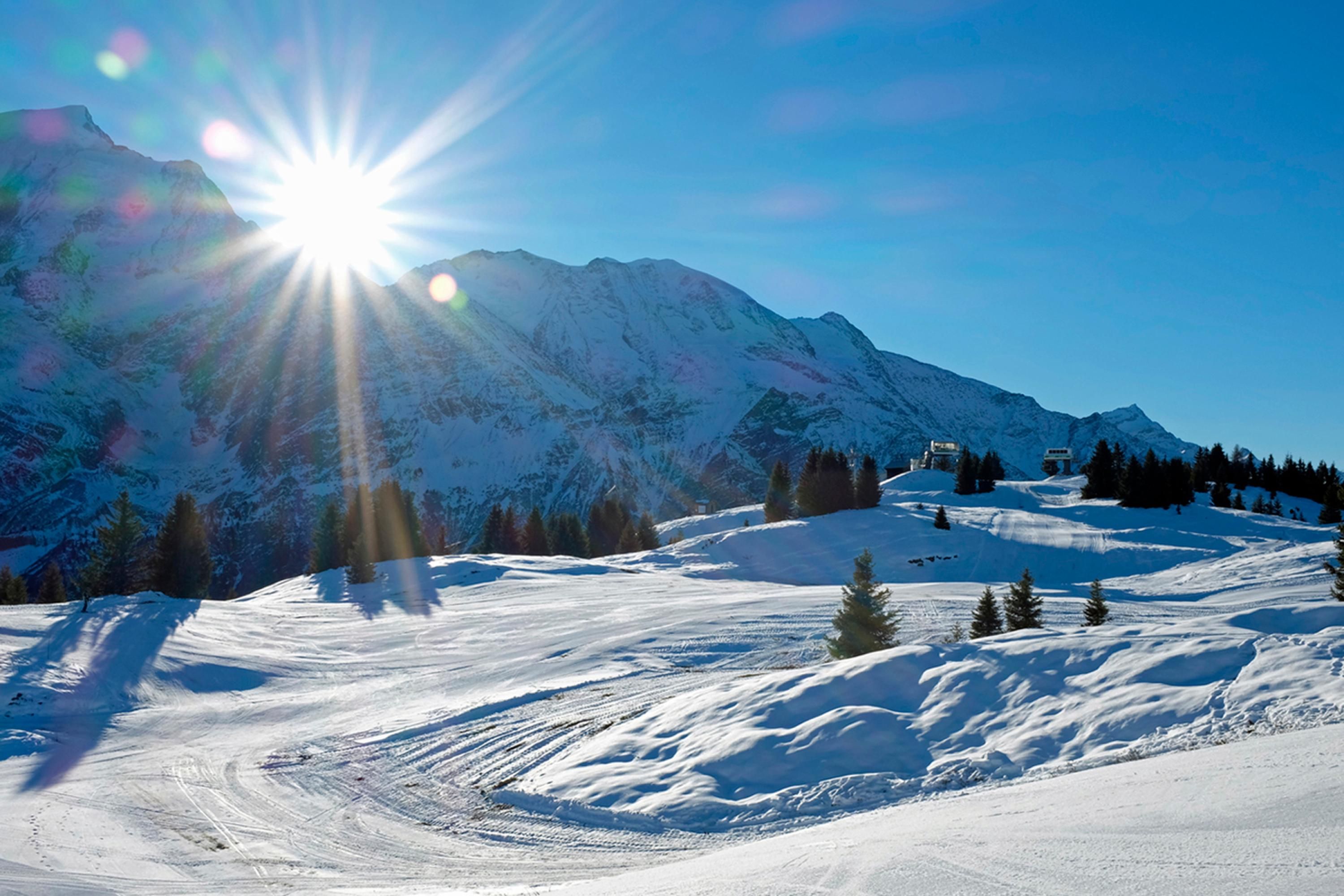 A snow-covered mountain landscape with a ski slope and a clear sky.