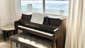 Un piano amb partitures davant d'una finestra que dona a un paisatge nevà.
