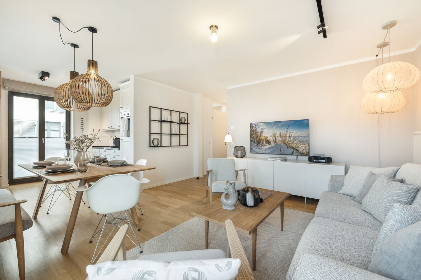 A modern living room with a dining area, a sofa, and a TV.