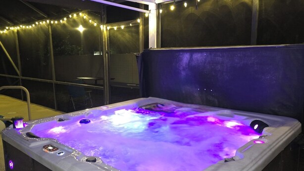 Un bain à remous doté d’un système de massage intégré, entouré de guirlandes lumineuses.