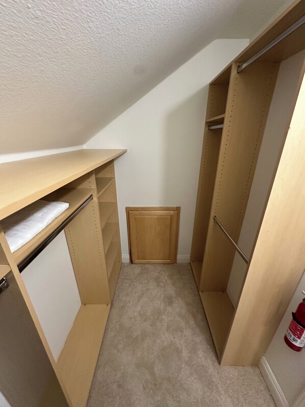 A narrow walk-in closet with wooden shelving and a small wooden cabinet. - Private & Cozy 1-bedroom guest house in delightful Alamo with WiFi, AC (Alamo)