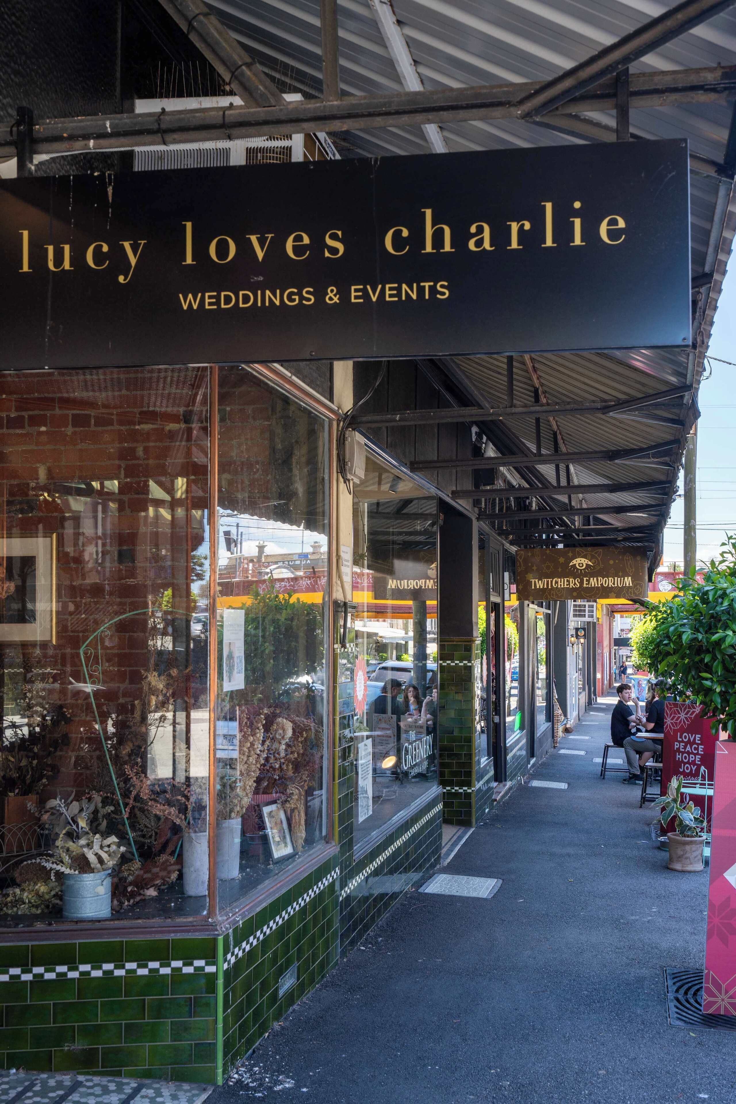 Fachada de un local con un cartel que dice 'Lucy loves Charlie Weddings & Events'.