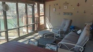 A wooden deck with a table and chairs, a ceiling fan, and a view of the outdoors. - Catfish Cove at Watts bar Lake (Rockwood)