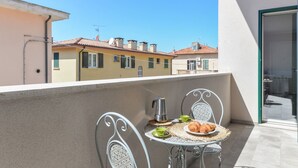 Een balkon met een ontbijtje, inclusief croissants en een koffiepot.