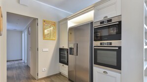 Een moderne keuken met roestvrijstalen apparatuur, een Bosch oven en een koelkast.