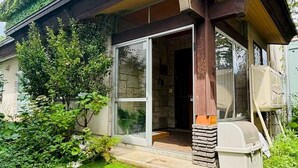 A modern house with a covered porch, a stone facade, and a well-maintained garden.