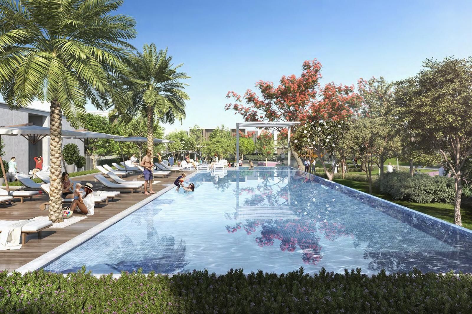 Una piscina con lettini e palme.