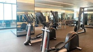 Ein Fitnessstudio mit Cardiogeräten, Spiegeln und Gewichten.