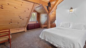 A bedroom with a wooden ceiling, a bed with white bedding, a nightstand, and a small window. - Lofted Legacy Barn,  White Mountains AZ (Heber)