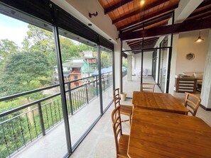 Enjoy meals at the dining table with a view of the surrounding residential area from the expansive balcony.