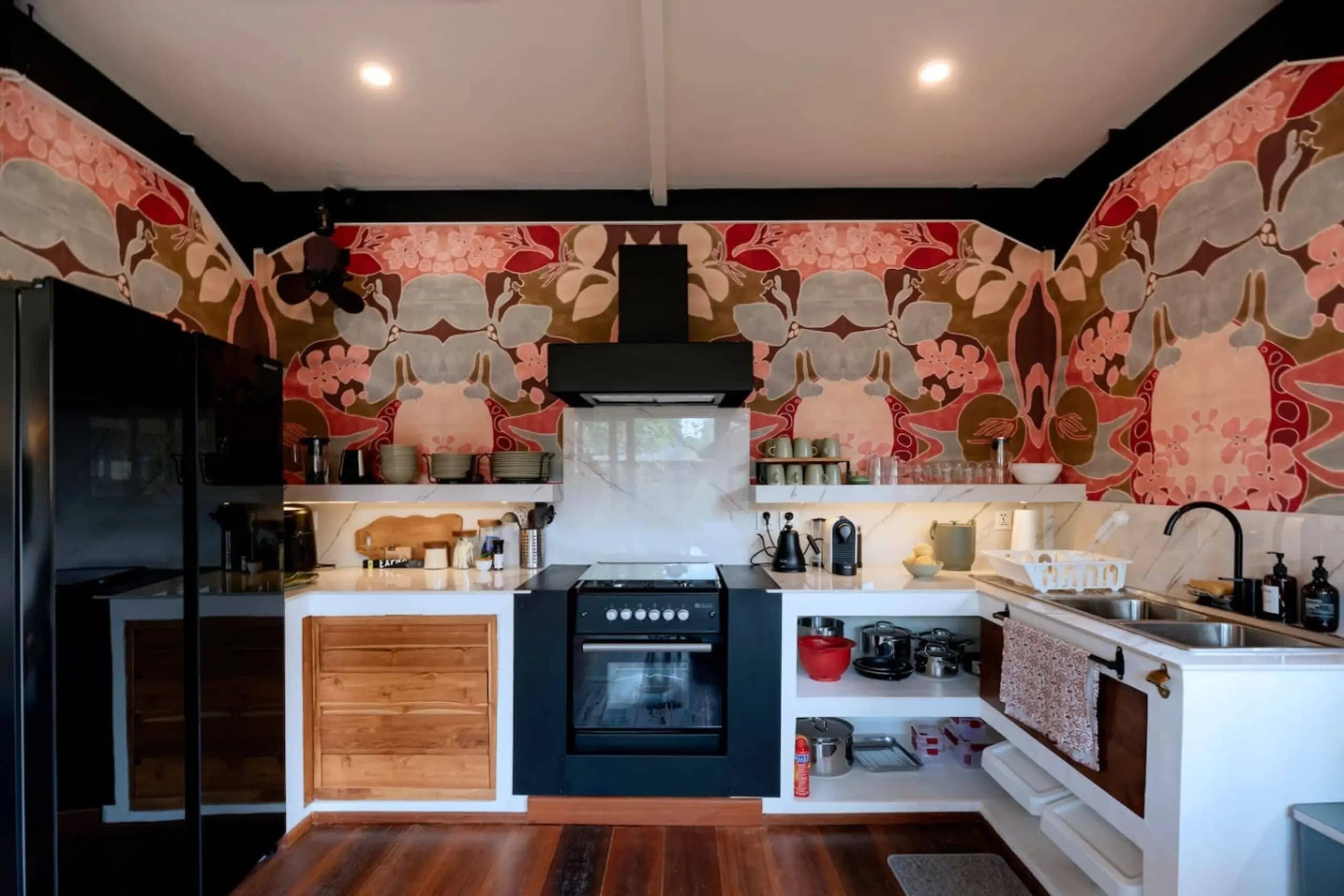 A modern kitchen with a central island, wooden cabinets, and a black oven.