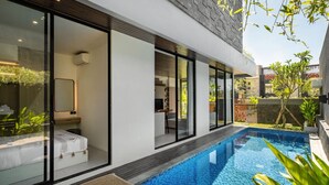 A modern house with a swimming pool, large glass windows, and a well-maintained garden.
