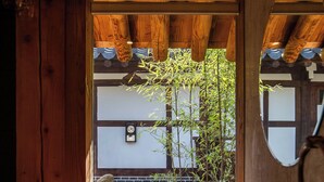 A wooden interior with a sink, a mirror, and a view of bamboo outside. - Ohsudang Hanok Stay (Gyeongju)