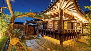 A traditional Japanese building with a wooden structure, stone pathway, and a tree in the foreground. - Ohsudang Hanok Stay (Gyeongju)