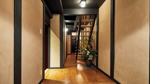 A hallway with wooden flooring, a staircase, and a potted plant. - Miro Shijo Kawaramachi Tei (Kyoto)