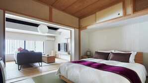 A modern bedroom with a large bed, a sofa, and a TV. - Miro Shijo Kawaramachi Tei (Kyoto)