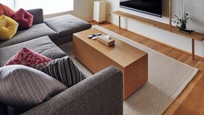 A modern living room with a wooden ceiling, a large flat-screen TV, a sofa set, and a coffee table. - Miro Shijo Kawaramachi Tei (Kyoto)
